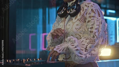A detailed close-up shot of a female DJ's hand operating a turntable, capturing the essence of a live DJ performance. The image highlights the turntable's jog wheel, knobs, and faders,