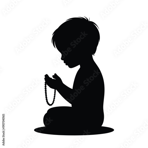 Silhouette of a young child kneeling and holding a string of beads