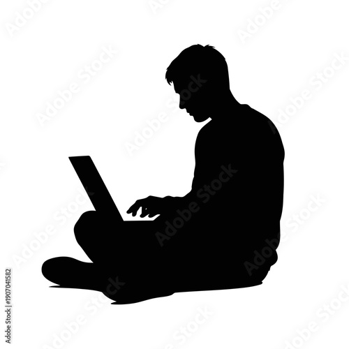 A silhouette of a man sitting cross-legged using a laptop
