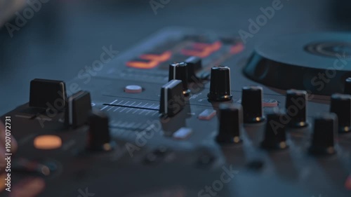 A detailed close-up shot of a female DJ's hand operating a turntable, capturing the essence of a live DJ performance. The image highlights the turntable's jog wheel, knobs, and faders,	