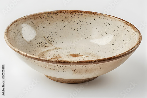 A speckled ceramic bowl is viewed from the side against a plain white background