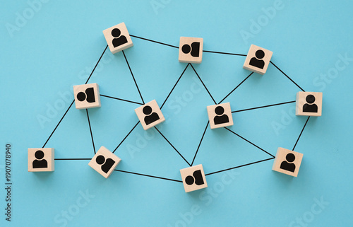 Organizational network structure with connected people icons on wooden blocks, showing team collaboration, stakeholder mapping, social graph. Business concept