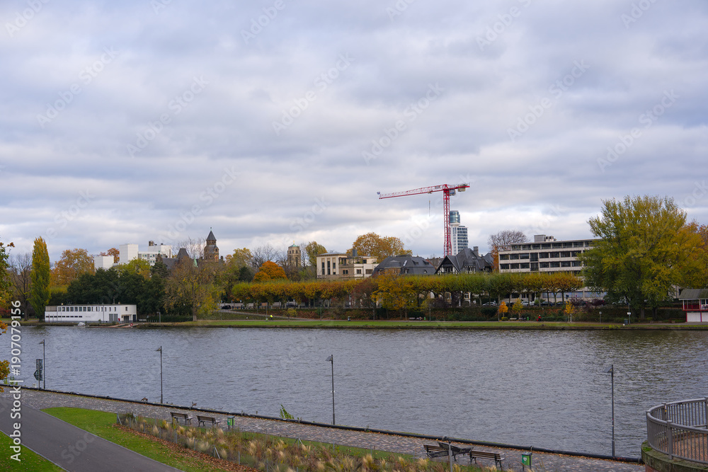 Fototapeta premium Scenic view of Main River with Sachsenhausen district in the background at German city of Frankfurt am Main on a cloudy autumn day. Photo taken November 3rd, 2025, Frankfurt am Main, Germany.