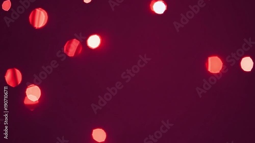 Abstract background with vibrant red bokeh lights on a dark surface creating a warm and festive atmosphere
