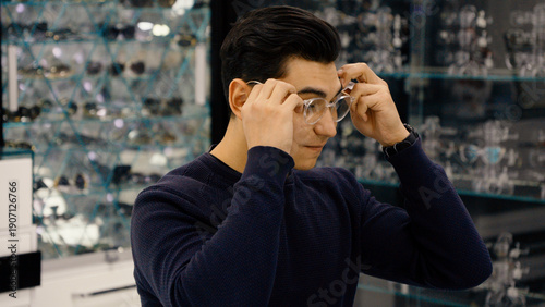 Εκτύπωση καμβά Young man trying on new glasses in optics store shop