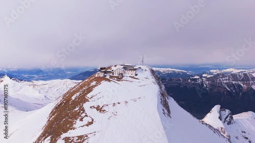 Faulhorn Mountain and Hotel at Summit on Winter Day. Bernese Alps. Switzerland. Aerial Drone Shot. Moving Upwards, Tilt Down