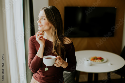 Woman enjoys tea while stan...