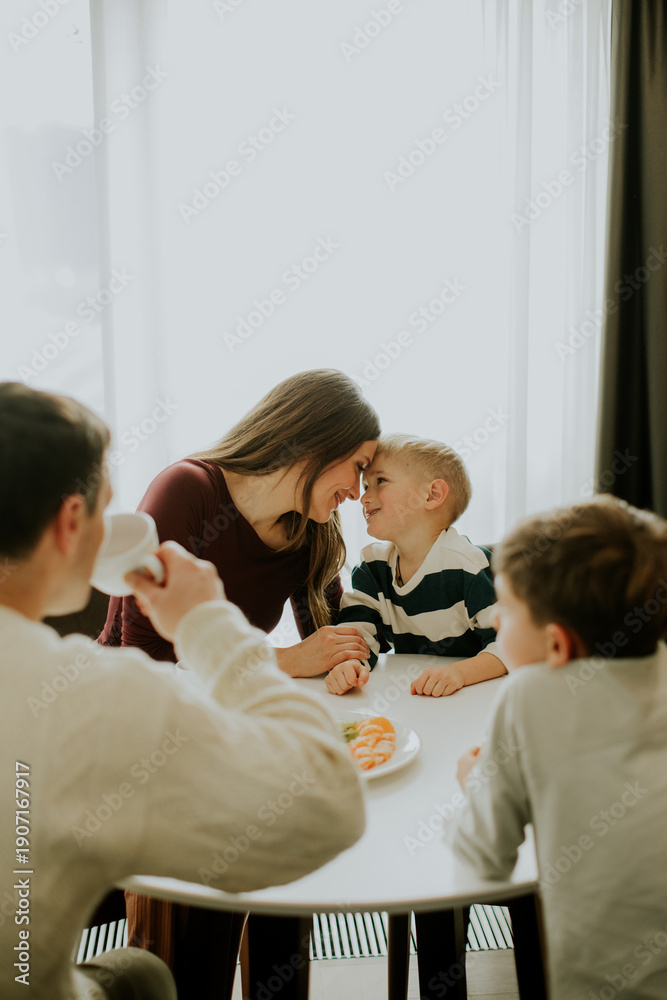 Obraz premium Family shares a meal together in a bright dining space during morning hours