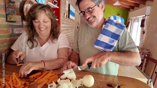 Senior couple happily cooking a meal together in the kitchen