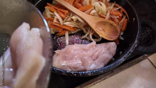 Man cooking chicken breast with vegetables