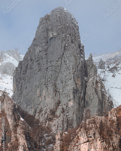 Canvas Print Dramatic winter view of Grignetta spires emerging from thick fog and low clouds