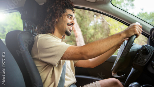 Latino man driving car and smiling with both hands on the steering wheel