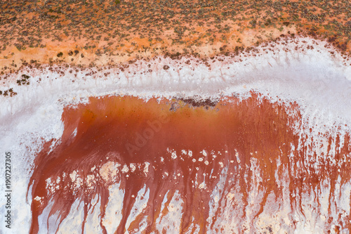 Rusty colored minerals seeping into a dry salt lake bed