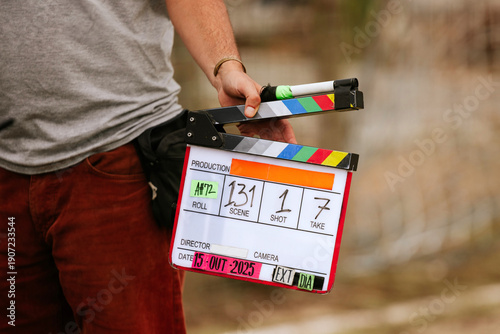 Film director holding a colorful movie clapperboard