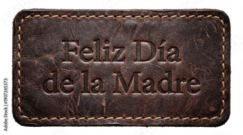 Embossed Spanish text Feliz Dia de la Madre on distressed dark brown leather patch with stitched border, isolated on white background