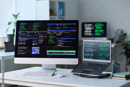 Принти на полотні Office workspace showing desktop computer and laptop displaying programming code