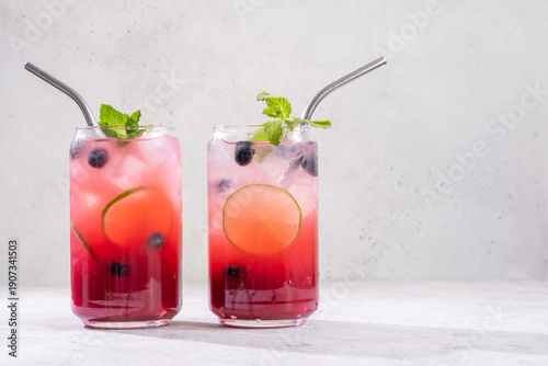 Fresh berry drinks with mint on a simple background