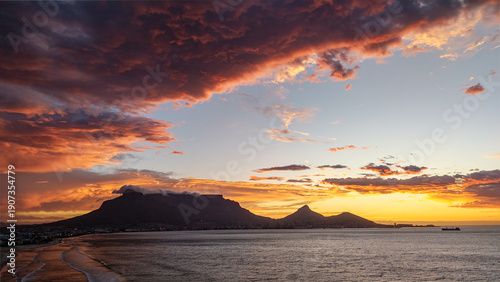 Konstfotografi Cape Town beach sunset with dramatic clouds and Table Mountain silhouette