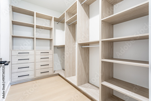 Canvastavla Modern walk in closet interior with custom wooden shelving, drawers and organize