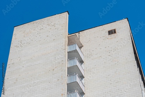 Φωτογραφία Clear day view of a tall, beige stone building with evenly spaced windows and a