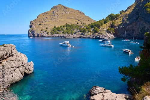 Breathtaking view of Sa Calobra bay with boats on turquoise blue water, Balearic Islands, Spain.