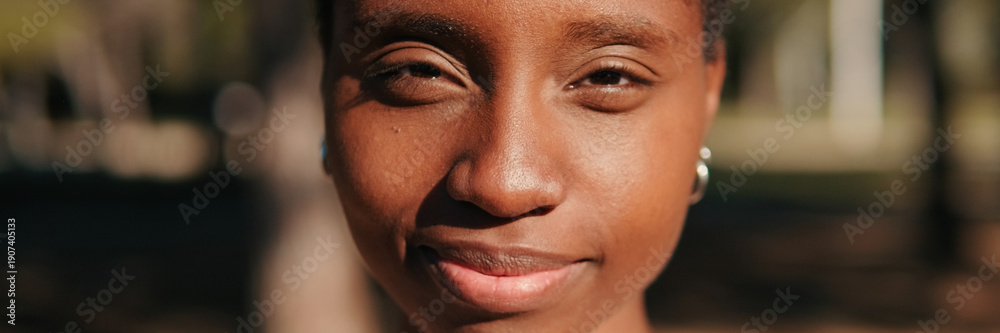 Fototapeta premium Close-up of happy young woman outdoors in the park. Panoramic. Panoramic