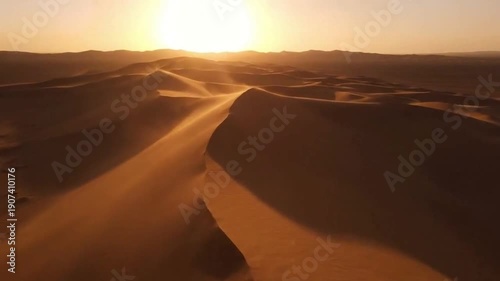 Aerial Sunset View of Rolling Sand Dunes with Wind-Blown Sand Particles