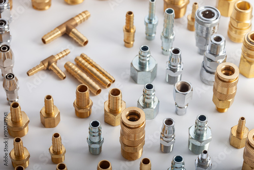 Large collection of brass and steel pneumatic fittings including hose barbs and quick couplers, professional industrial hardware assortment for fluid engineering and workshop maintenance systems