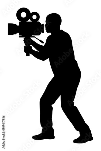 Silhouette of a filmmaker operating a large vintage movie camera recording video