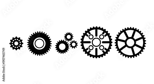 Diverse collection of black mechanical gears in varying sizes and designs arranged horizontally on a clean white background