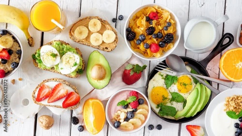 Wallpaper Mural Healthy breakfast table scene with fruit, yogurts, oatmeal, smoothie, nutritious toasts and egg skillet. Slow rotating zoom motion. Overhead view on a white wood background. Torontodigital.ca