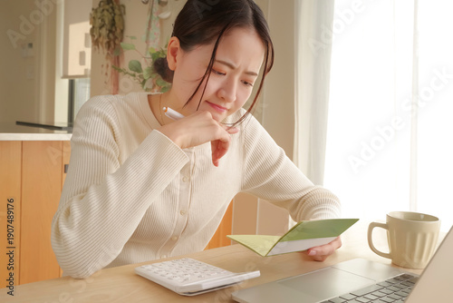 Tableau sur toile 通帳をみてお金の管理をする女性