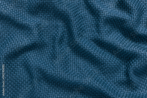 Detailed texture of deep blue woven fabric background. Top view of petrol colored thick throw blanket material with a basket weave pattern, softly draped to create an abstract background