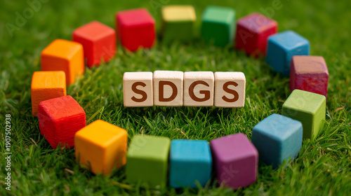 SDGs Wooden Cubes on Green Grass with Colorful Blocks – Sustainable Development Goals Concept