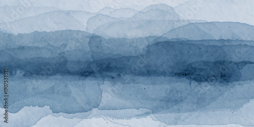 Panoramic winter mountain landscape featuring frozen arctic glaciers and snow covered peaks under a blue sky with white clouds in Iceland or Antarctica