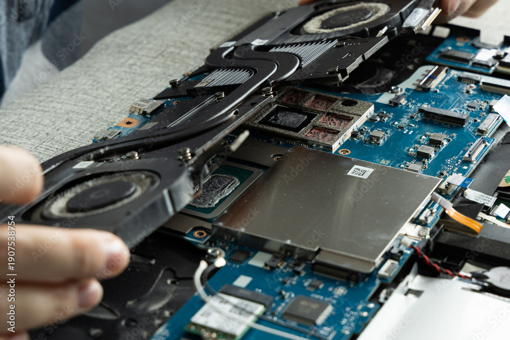 Fototapeta premium Repairing a Laptop and Replacing the Cooling System at a Workbench in a Tech Shop