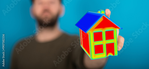 A man holds a model house d...
