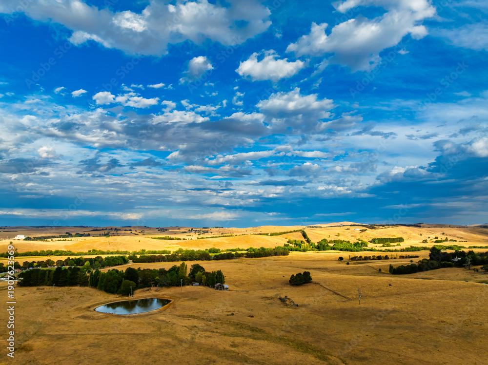 Obraz premium Cloud‑Laced Skies at Golden Hour Over Farmland
