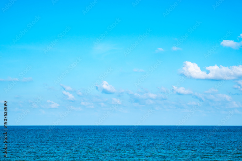 Fototapeta premium Tropical Nature clear sky and summer sea water under a clear blue sky with beautiful clouds and bright sunlight. Perfect for summer vacation and travel background