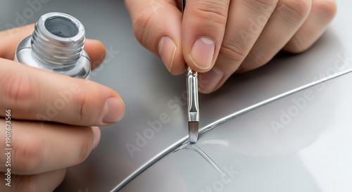 Close-up on Hand Applying Touch-Up Paint Pen to Minor Scratch on Silver Car Bumper, DIY Scratch Repair Kit Application