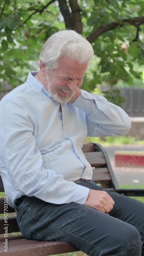 Tired Senior Old Man Sitting Outdoor with Neck Pain, vertical video