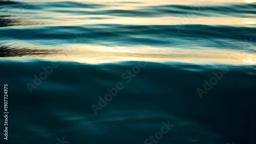 Abstract depiction of water with turquoise and gold hues reflecting light