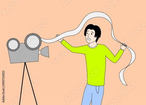 Man is holding a roll of film. He is standing in front of a camera. The camera is on a tripod