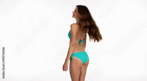 A woman in a teal bikini standing against a white background