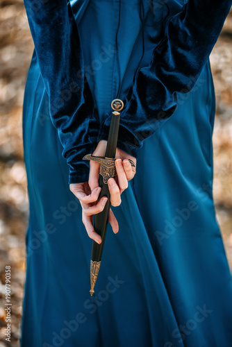 Fotografie A mysterious medieval woman conceals a dagger behind her back