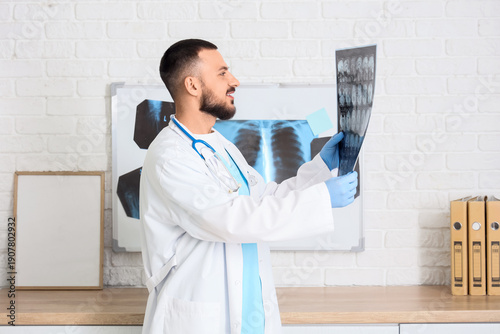 Male doctor studying MRI scan of head in clinic