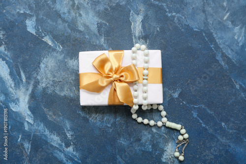Tasbih and gift box on blue...