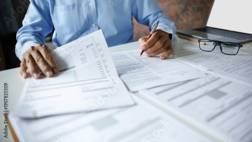 close up shot, accountant working with laptop reviewing the company's accounts and financial documents on desk
