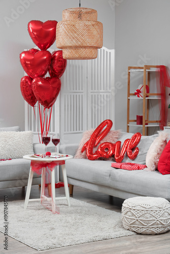 Interior of living room decorated for Valentine's Day with sofas and balloons