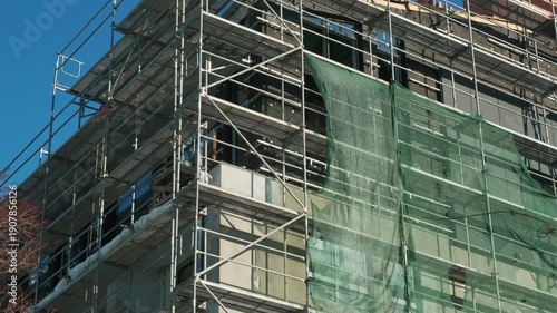 Wallpaper Mural Scaffolding erected around a building under renovation. Construction industry site with metal structure for repair work on a facade. Torontodigital.ca